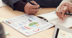 Artykuł współautorstwa naszego pracownika w czasopiśmie  Journal of Environmental Management wydawnictwa Elsevier - zdjęcie przedstawia stół wraz z notatkami i wykresami oraz dłońmi osób