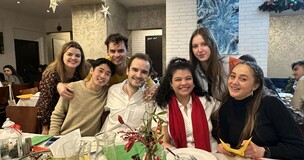  International students smiling and posing together during a Christmas-themed gathering.