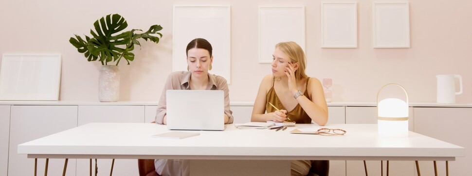 dwie dziewczyny siedzące przed komputerem