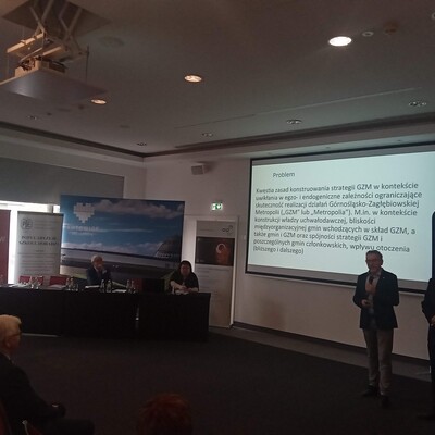 dwie osoby prowadzące wykład z wyświetloną prezentacja multimedialną