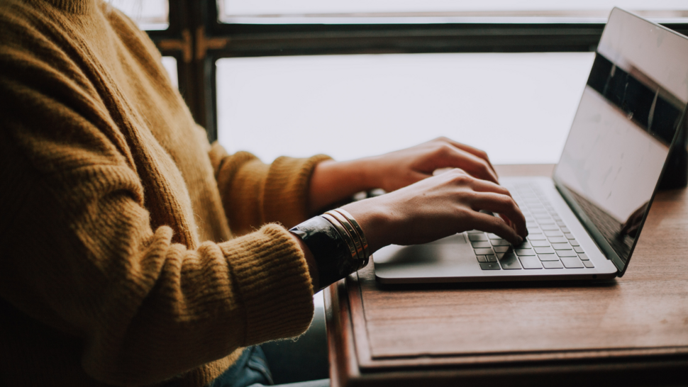 women writing something on her laptop