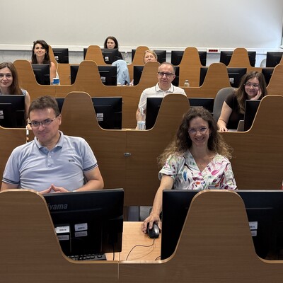 Zdjęcie grupowe z przodu, za komputerami.