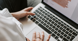 Obrazek przedstawia osobę przy laptopie