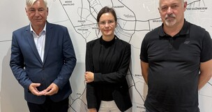 Zdjęcie prezentujące uczestników spotkania w JTBS na tle mapy miasta