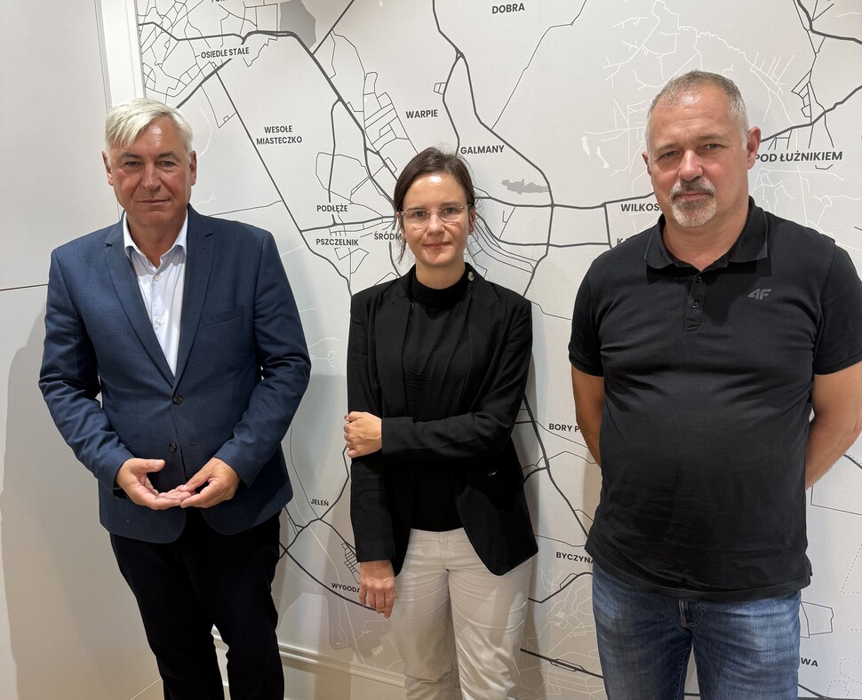 Zdjęcie prezentujące uczestników spotkania w JTBS na tle mapy miasta