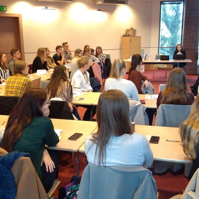 Uczestnicy projektu Akademia Kariery, siedzą przy stolikach i słuchają prelegenta