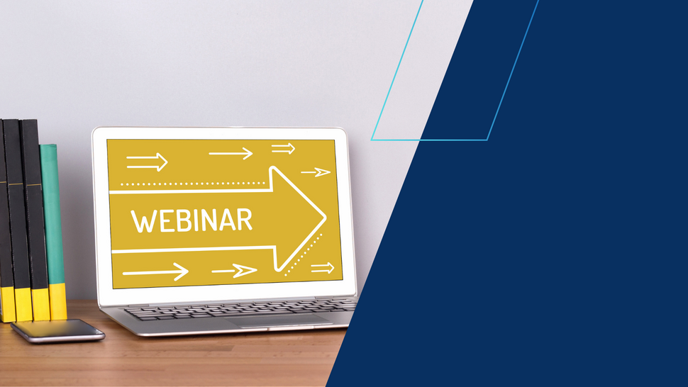Laptop stojący na drewnianym biurku wyświetla żółty ekran z napisem ‘Webinar’ i białą strzałką skierowaną w prawo; obok znajdują się książki oraz smartfon. Tło po prawej stronie stanowi granatowy blok graficzny.