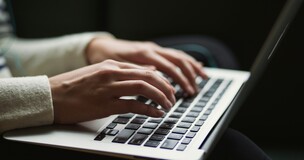 dłonie na klawiaturze laptopa