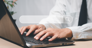 dłonie mężczyzny, który trzyma je na klawiaturze laptopa