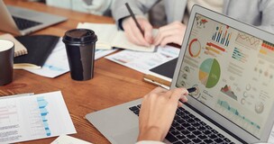 Obrazek przedstawia osoby omawiające informacje dotyczące budowania CV.