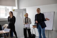 3 kobiety stojące przed publicznością