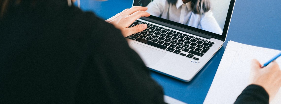 Webinarium na temat bezpieczeństwa w biznesie - grafika ilustrująca przedstawia fragment laptopa i osobę robiącą notatki