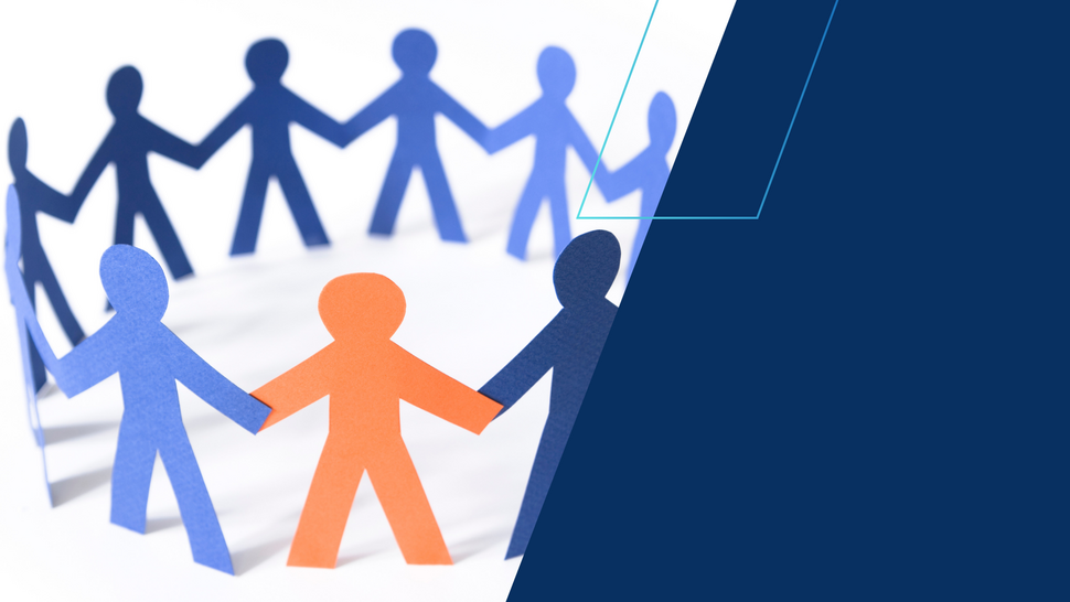 Papierowe sylwetki ludzi trzymających się za ręce, ustawione w kręgu. Jedna postać w kolorze pomarańczowym wyróżnia się na tle niebieskich, symbolizując wsparcie, integrację i wspólnotę. Po prawej stronie granatowy element graficzny.