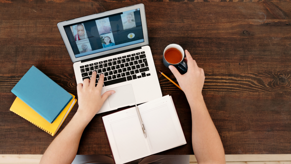 rozmowa online, laptop na stole obok książki