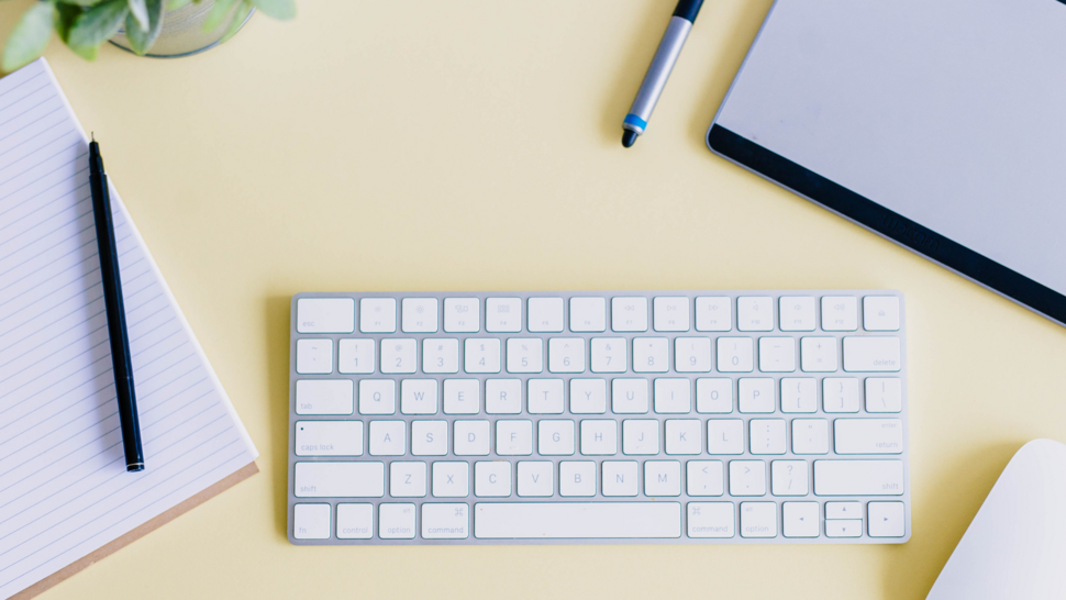 notes, klawiatura i długopisy na biurku