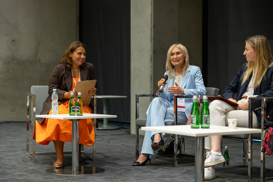 JM Rektor prof. Celina M. Olszak uczestniczy w panelu dyskusyjnym podczas Kongresu Kobiet. Siedzi na fotelu w jasnym garniturze, rozmawia z innymi panelistkami. 