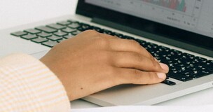 Pracownik Uczelni redaktorem czasopisma "Annals of Tourism Research" - zdjęcie przedstawiające dłoń na klawiaturze laptopa
