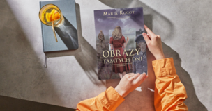 książka na stole, którą trzymają kobiece dłonie