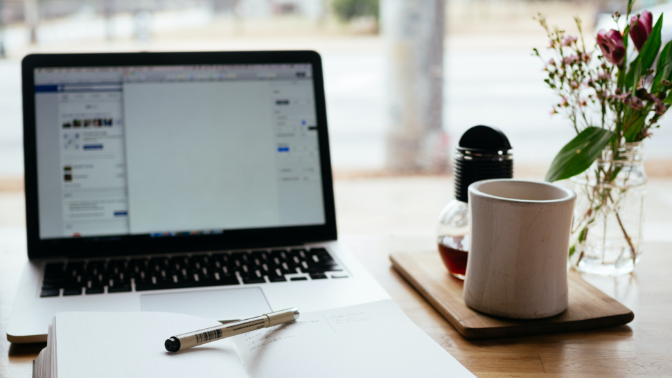 laptop, notes i doniczka z kwiatkiem na biurku