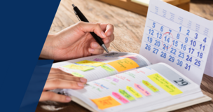 Student’s hands writing notes in a colorful university class guide for the winter semester.