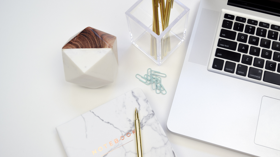 pens, laptop and notebook on the desk