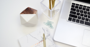 pens, laptop and notebook on the desk