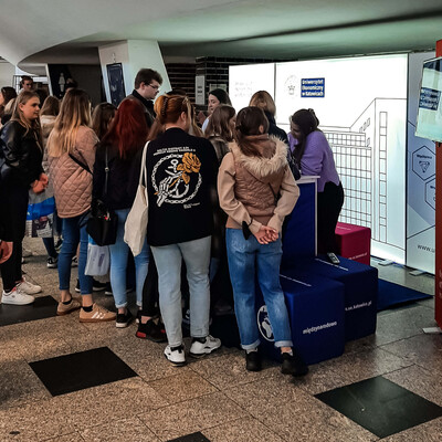 grupa studentów zgromadzonych wokół stoiska promocyjnego