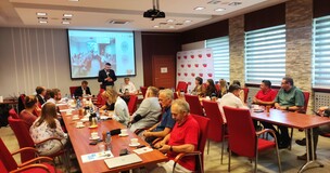 Zdjęcie prezentujące zebranych na sali uczestników spotkania.