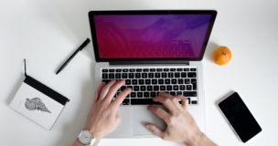 laptop na biurku z pomarańczą