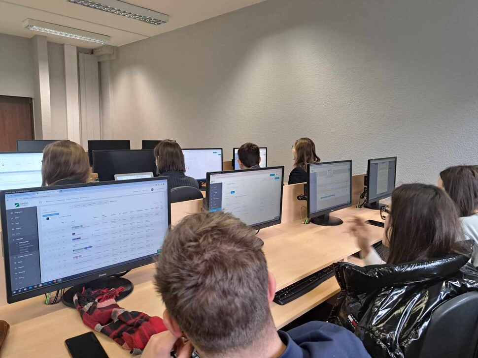 Studenci w Sali komputerowej pracujący przy aplikacji SinguFM