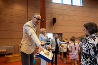 Kanclerz Paweł Kadłubiak wręczający upominki dzieciom