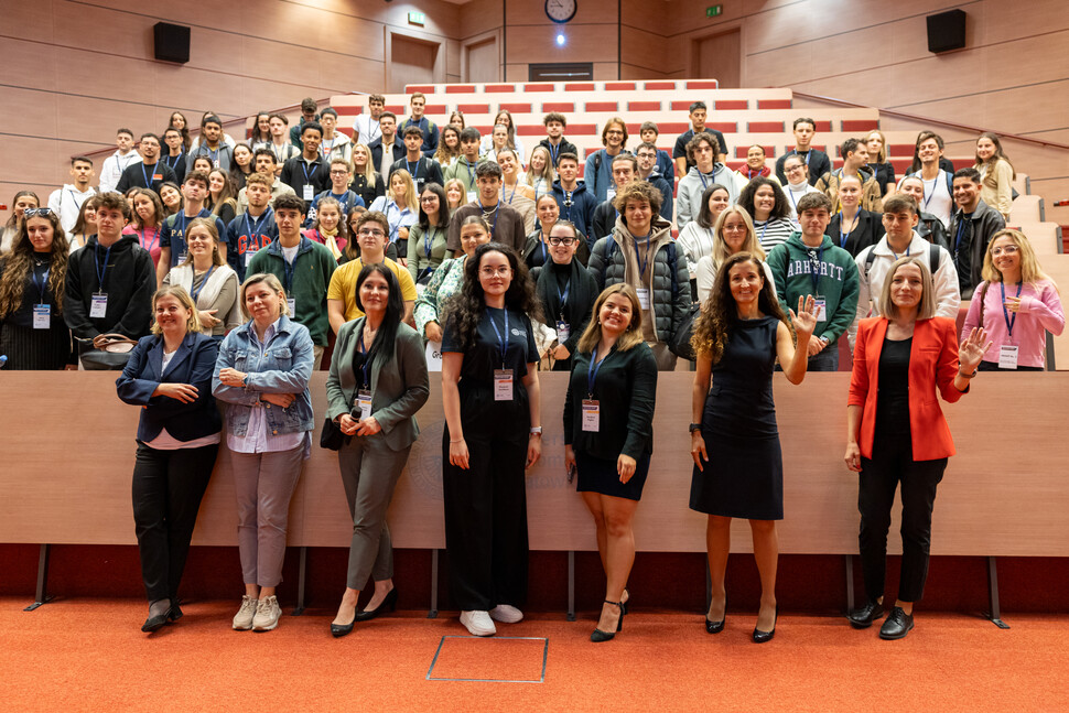 Large group of university staff, officials and students posing on stage during the formation of the new advisory board.