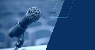 Grafika ozdobna: mikrofon, w tle rozmyte siedzenia sali konferencyjnej