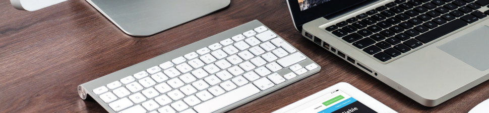 Artykuł pracowników Katedry Bankowości i Rynków Finansowych w wysoko punktowanym czasopiśmie - zdjęcie przedstawia klawiatury laptopa i komputera na drewnianym podłożu