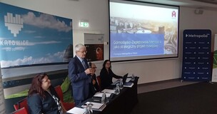 uczestnicy konferencji z wyświetloną prezentacja multimedialną