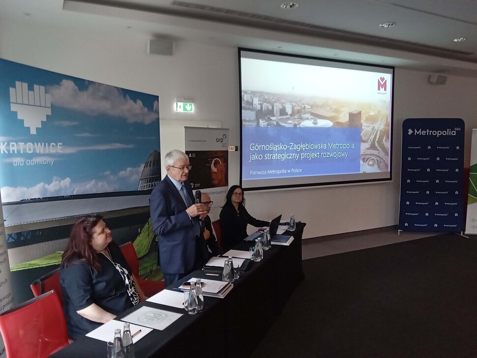 uczestnicy konferencji z wyświetloną prezentacja multimedialną