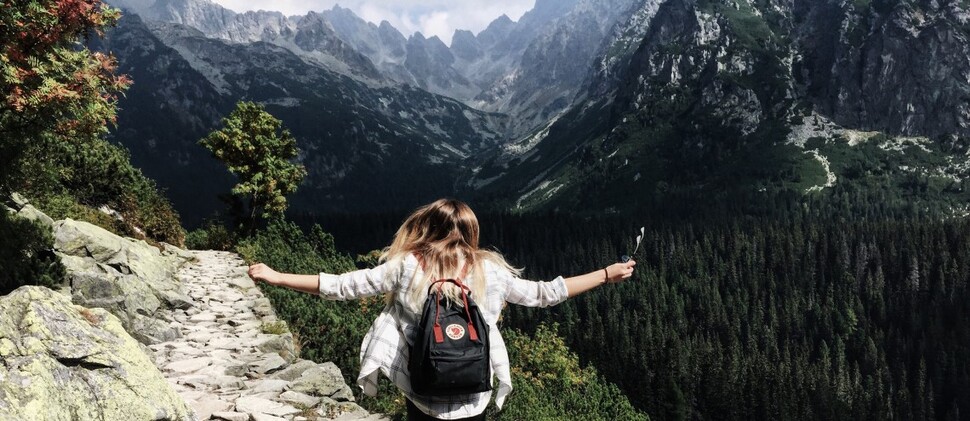 dziewczyna z plecakiem spacerująca w górach