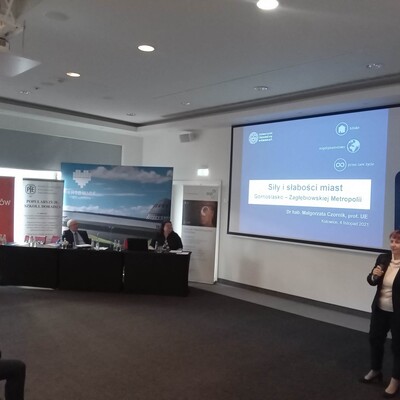 osoba prowadząca wykład z wyświetloną prezentacja multimedialną