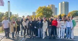 Group photo of students and faculty posing outdoors in autumn scenery for a photography project.