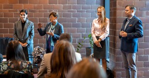 Professor giving a speech in front of colleaguesand faculty members during a workshop and award ceremony.