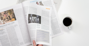 gazeta obok której leży czarna kawa