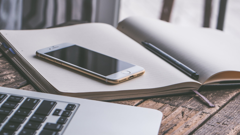 computer, phone and notes lay down on the desk