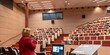 zdjęcie wykonane z tyłu prelegenta, w tle uczestnicy siedzący na Auli