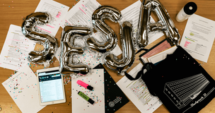 balony ułożone w napis "SESJA" dookoła notatki, długopisy i zakreślacze