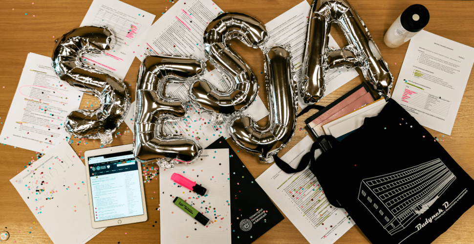 balony ułożone w napis "SESJA" dookoła notatki, długopisy i zakreślacze