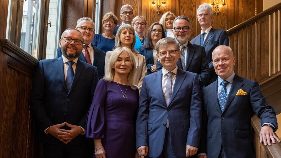 Group of formally dressed university leaders posing for a photo after appointments to management roles.