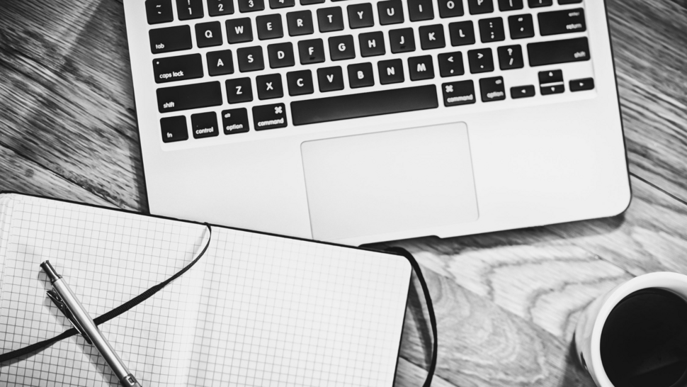 laptop, notebook and cup of coffe lay down on the desk