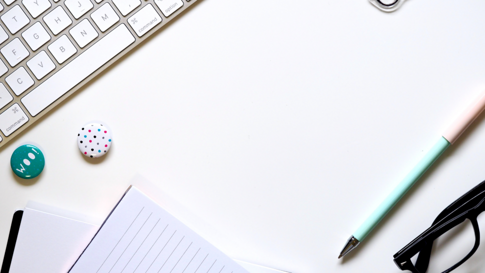 klawiatura, długopisy i okulary leżące na biurku