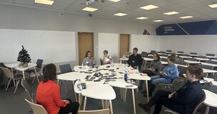 University classroom with students sitting at tables during a well-being themed event.