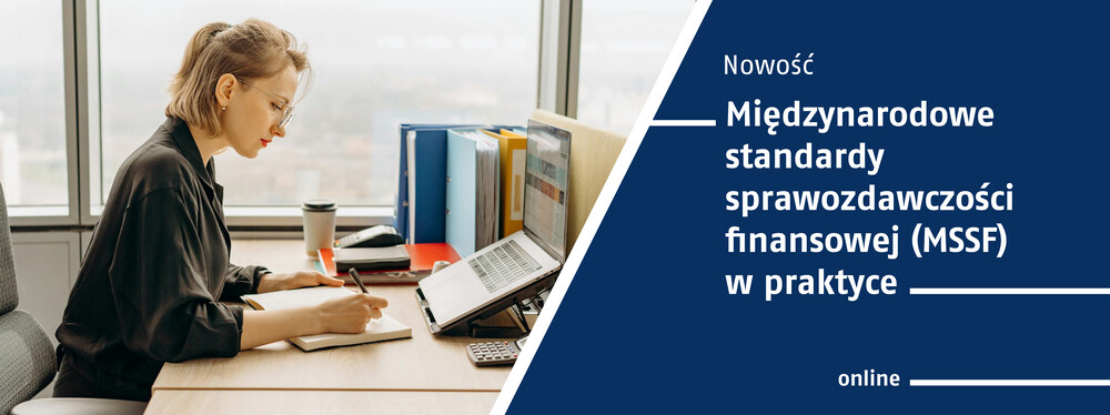 Młoda kobieta w pracy - siedząca przy biurku i przy komputerze